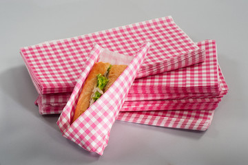 sandwich wrapped in a pink plaid paper