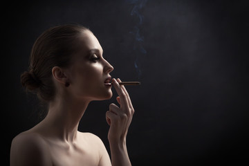 luxury woman smoking cigarette on black background