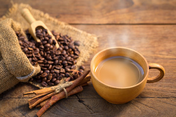 Coffee cup and coffee beans on wooden background.