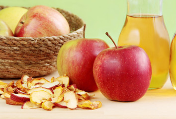Fresh apples, dried apples and apple juice on wooden background.