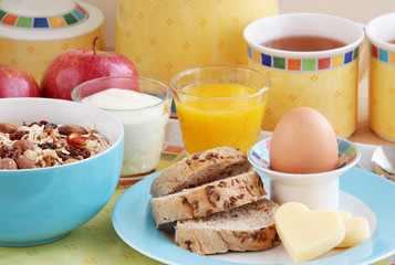 Healthy breakfast. Oat flakes, raisins, almonds, nuts, dried apples, egg, wholemeal bread, cheese, apples, orange juice and yogurt. Closeup view.