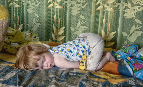 Girl Child Sleeping In A Funny Position In Bed