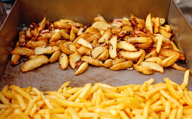 Steel container with roasted potato wedges, french fries