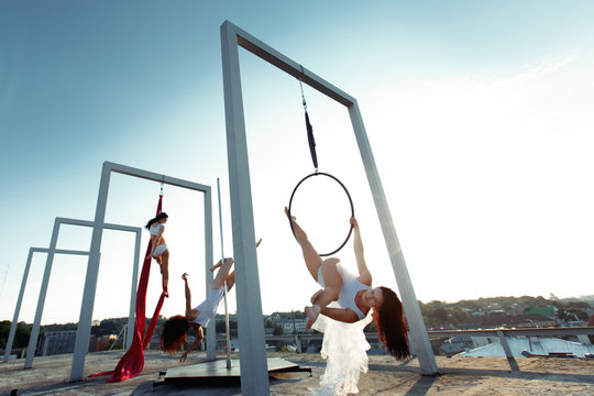 Athletic dancers performing aerial & pole dance on rooftop