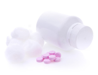 Pills spilling out of pill bottle on white background