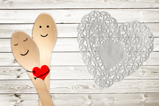 Happy couple hug concept, smiley painted on spoons, valentines day background