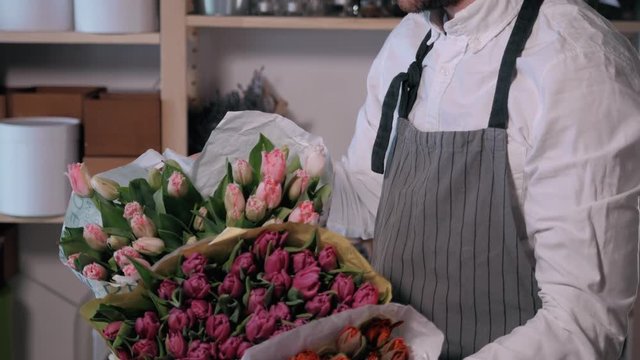 Close up florist hands. man making bunch at flower shop. people, business, sale and floristry concept. Bouquet with roses, peone, lilac and lisianthus