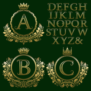 Vintage monogram kit. Golden patterned letters and floral coat of arms frames for creating initial logo in antique style.