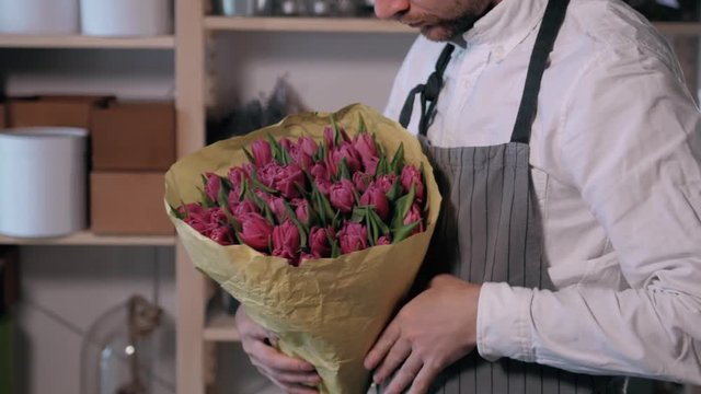 Close up florist hands. man making bunch at flower shop. people, business, sale and floristry concept. Bouquet with roses, peone, lilac and lisianthus