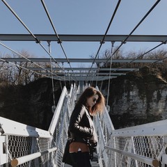 девушка идет по мосту в горах