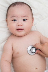 Doctor using a stethoscope to listen to baby's chest