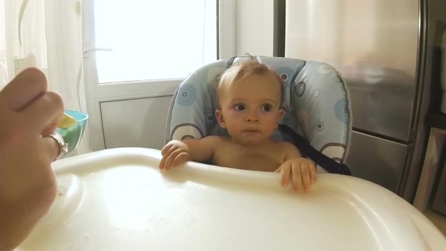 POV video of young mother feeding her baby son with soup