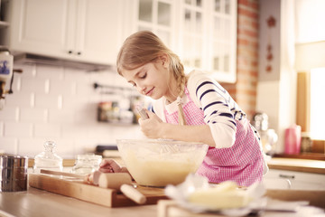 Little girl learning how to make proper dough.