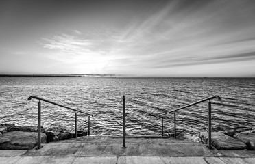 Steps on a beach with sunset on the ocean sea.