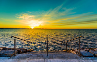 Steps on a beach with sunset on the ocean sea.