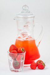 glass decanter with strawberry juice and ice
