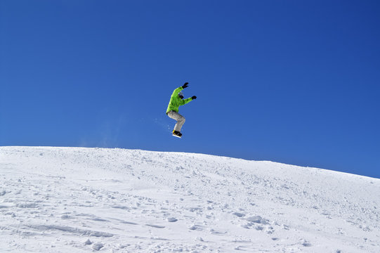 Snowboarder jump in snow park at ski resort on sun day