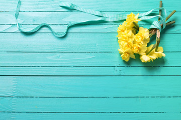 Bunch of  yellow  daffodisl flowers on turquoise wooden backgrou