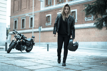 Naklejka na ściany i meble biker girl in a leather jacket on a motorcycle