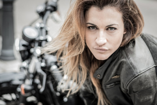 biker girl in a leather jacket on a motorcycle