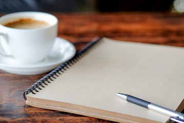 Pen on notebook with coffee.