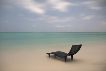 Fototapeta na wymiar Amazing landscape of lonely sunbed on the beach