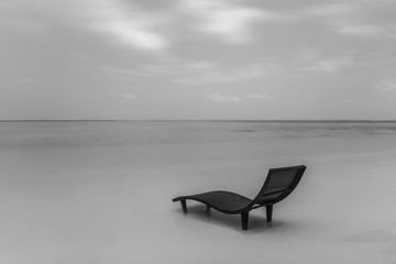 Black and white landscape of lonely sunbed on the beach