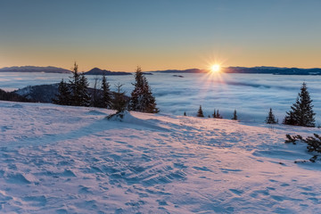 Amazing mountain sunrise above inversion low clouds