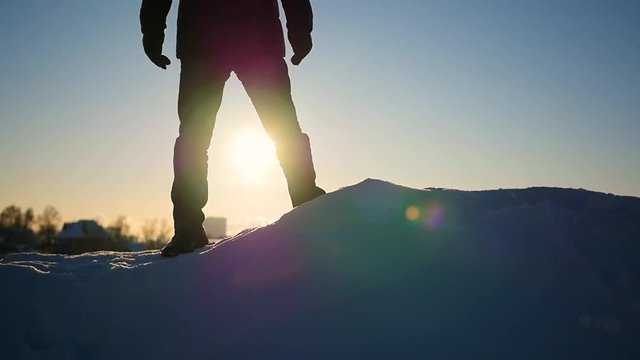 the guy is on a snow slope and raises his hands up at sunset.snow winter landscape. outdoors sports