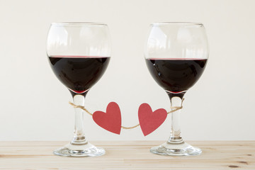 Two glasses of red wine, tied with red hearts