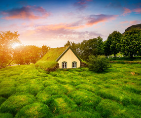Obraz premium Picturesque turf-top church in small village Hof. Colorful sunset in Skaftafell in Vatnajokull National Park, southeast Iceland, Europe. Artistic style post processed photo.
