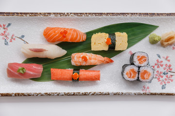 Sushi Set Include Maguro, Hamachi, Salmon, Kani, Shrimp, Tamagoyaki and Salmon Maki Roll Served with Wasabi and Prickled Ginger on Japanese Painted Stone Plate.