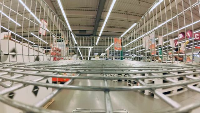 POV footage from inside the shopping cart of going through big supermarket