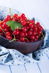 Ripe red currant in wooden bowl