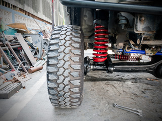 Fototapeta na wymiar Closeup front wheel and suspension of the four-wheel drive pickup truck.