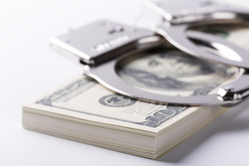 Pair of handcuffs closeup on dollar and euro banknotes stacks