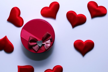 Pink round gift box with a bow and red heart on a white background