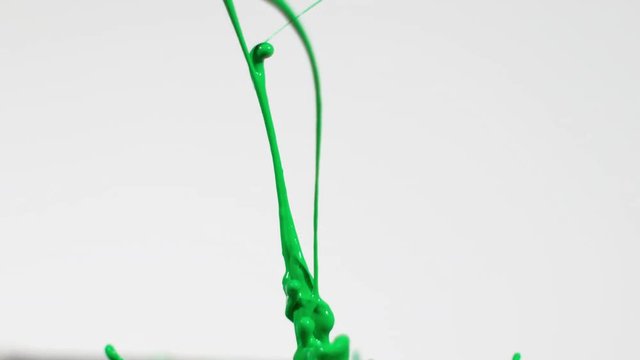 Green chroma key paint on white background shot in slow motion