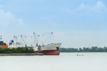 Container Cargo freight ship with working crane bridge in shipyard in Thailand.