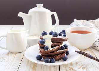 Hot tea and buckwheat chocolate pancakes with blueberries