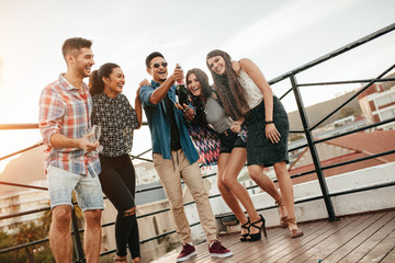 Obraz premium Young friends celebrating with champagne at party