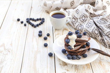 Hot coffee and buckwheat chocolate pancakes with blueberries