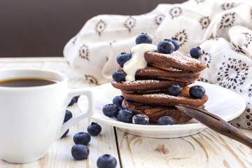 Hot coffee and buckwheat chocolate pancakes with blueberries