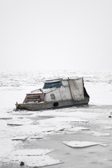 Fototapeta na wymiar Boat on a frozen river