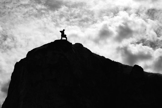 Young businessman standing on edge of rock