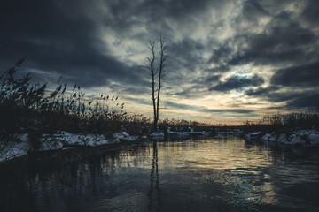 Fototapeta na wymiar Winter river scenic landscape with cloudy sunset.