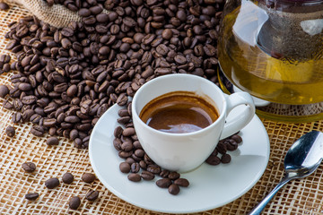 Cup of coffee on coffee beans background on a wooden table