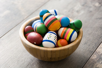Fototapeta na wymiar Colorful Easter eggs in a bowl on wooden table 