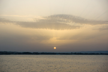 calm sea with the sun sitting down in it