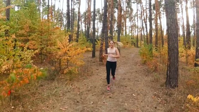 Slow motion video of beautiful sexy woman running at autumn forest